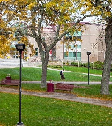 A person crossing the quad on a fall day